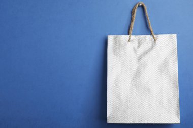 Mavi arkaplanda gümüş alışveriş poşeti, metin için boşluk