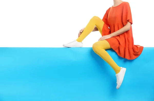 Женщина в жёлтых колготках и стильной обуви, сидящая на цвету Б — стоковое фото