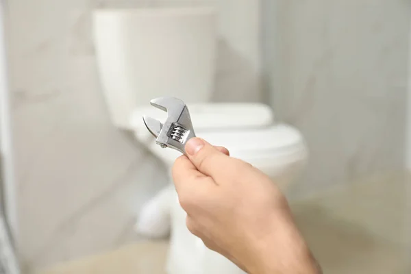 Professional Plumber Holding Wrench Toilet Bowl Bathroom Closeup — ストック写真