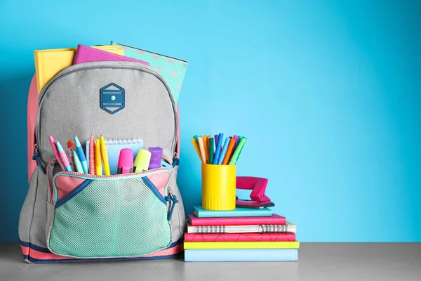 Stijlvolle Rugzak Met Verschillende Schoolspullen Tafel Tegen Lichtblauwe Achtergrond Ruimte — Stockfoto