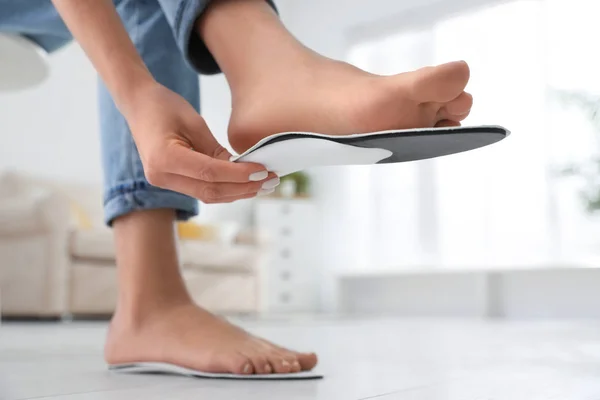 Woman fitting orthopedic insole at home, closeup — Stock Photo, Image