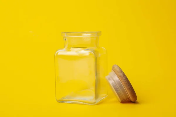 Frasco de vidro vazio aberto no fundo amarelo — Fotografia de Stock