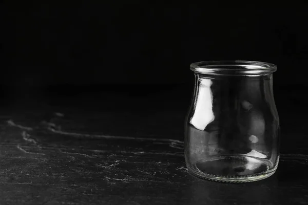 Frasco de vidro vazio na mesa de pedra preta, espaço para texto — Fotografia de Stock
