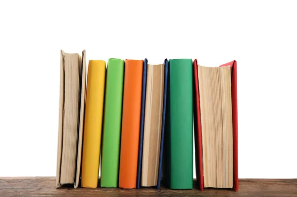 Beyaz arka plana karşı ahşap masadaki renkli kitaplar — Stok fotoğraf