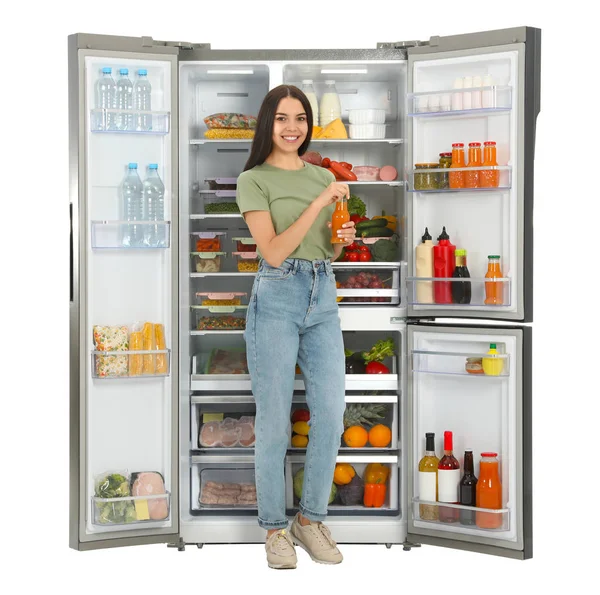 Jovem Com Garrafa Suco Perto Refrigerador Aberto Fundo Branco — Fotografia de Stock