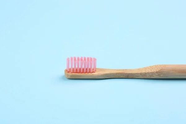 Escova de dentes feita de bambu no fundo azul claro — Fotografia de Stock