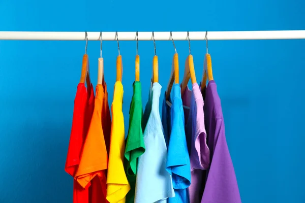 Heldere kleren op blauwe achtergrond. Regenboog kleuren — Stockfoto