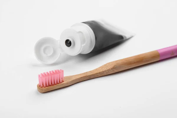 Escova de dentes de bambu e pasta de carvão isolado em branco — Fotografia de Stock