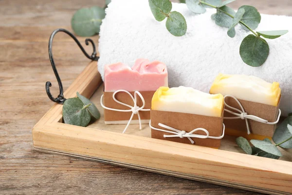 Natural handmade soap bars in tray on wooden table, closeup