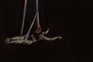 Genç bir kadın hava ipeğine karşı akrobatik bir element sergiliyor. 