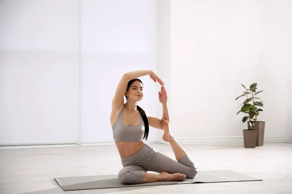 Young woman practicing mermaid asana in yoga studio. Eka Pada Ra — ストック写真