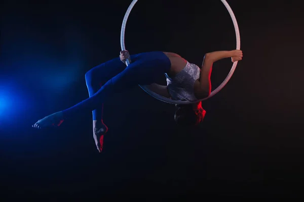 Giovane donna che esegue elemento acrobatico su anello aereo contro — Foto Stock