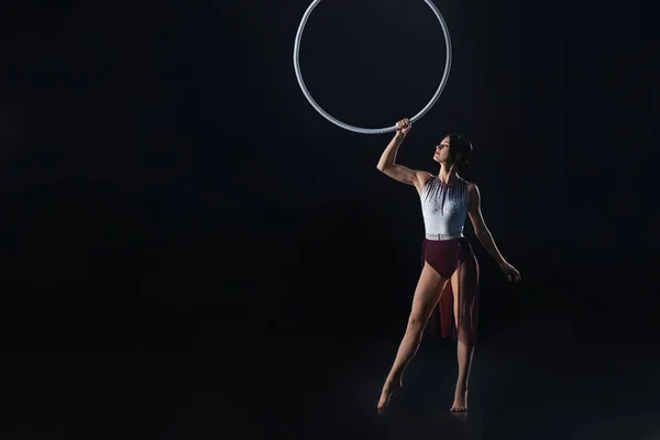 Jeune femme exécutant élément acrobatique sur anneau aérien contre — Photo