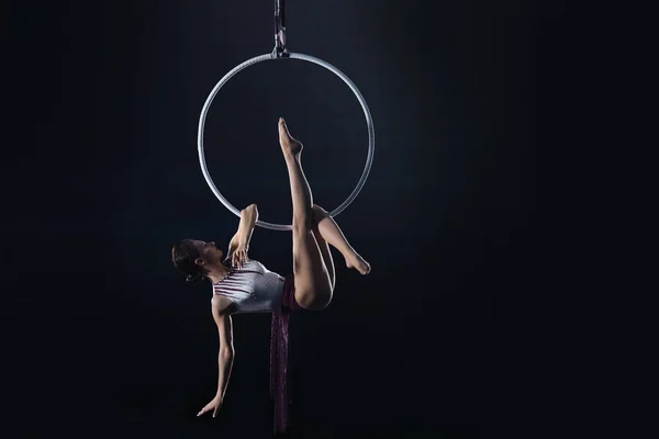 Mujer joven realizando elemento acrobático en anillo aéreo en interiores —  Fotos de Stock