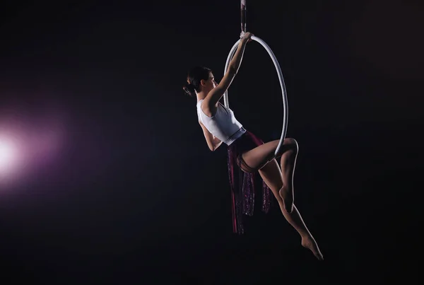 Genç bir kadın hava halkası üzerinde akrobatik bir element sergiliyor. — Stok fotoğraf