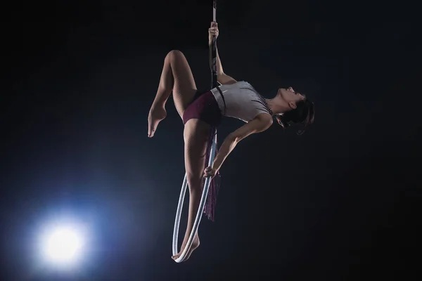 Giovane donna che esegue elemento acrobatico su anello aereo contro — Foto Stock