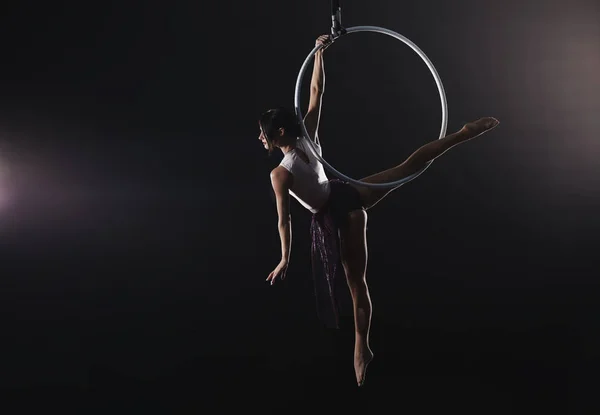 Mujer joven realizando elemento acrobático en anillo aéreo contra —  Fotos de Stock