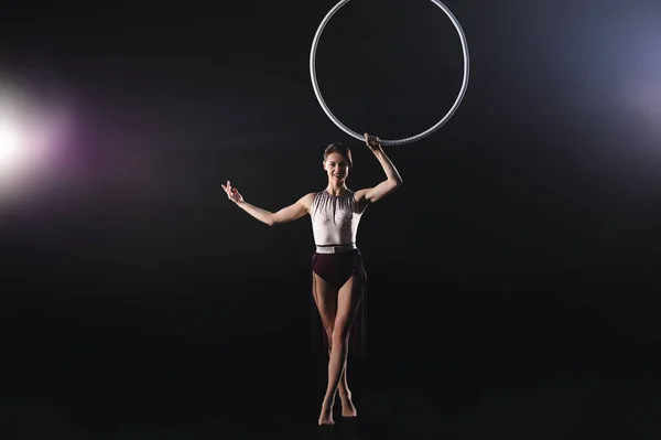 Młoda kobieta wykonująca element akrobatyczny na pierścieniu powietrznym w pomieszczeniu — Zdjęcie stockowe
