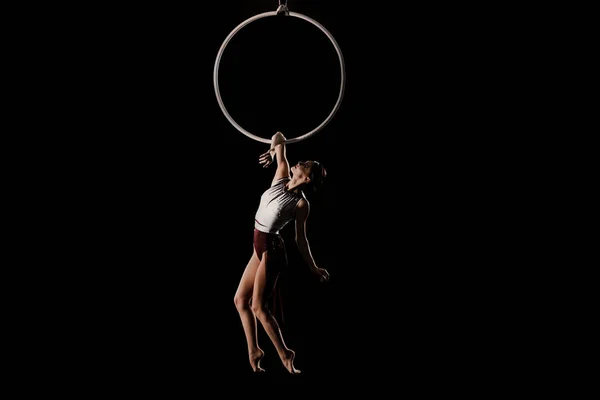Mujer joven realizando elemento acrobático en anillo aéreo en interiores — Foto de Stock