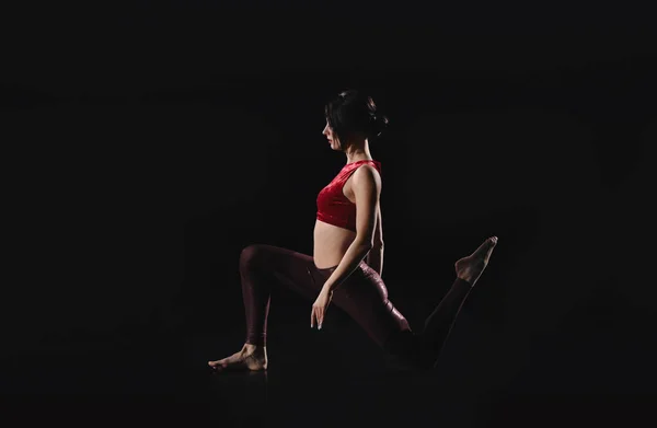 Mulher jovem realizando elemento acrobático no palco dentro de casa — Fotografia de Stock