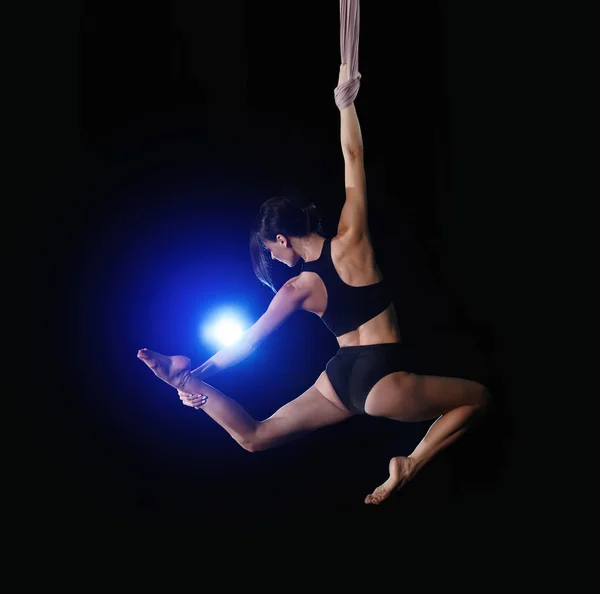 Mujer joven realizando elemento acrobático en seda aérea en interiores — Foto de Stock