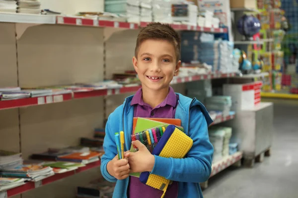 Little boy choosing school stationery in supermarket