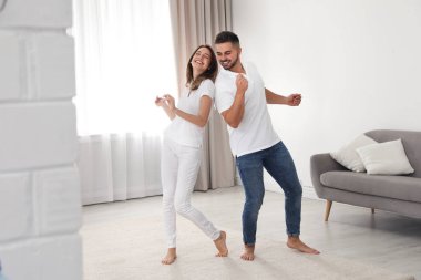 Güzel genç çift evde dans ediyor.