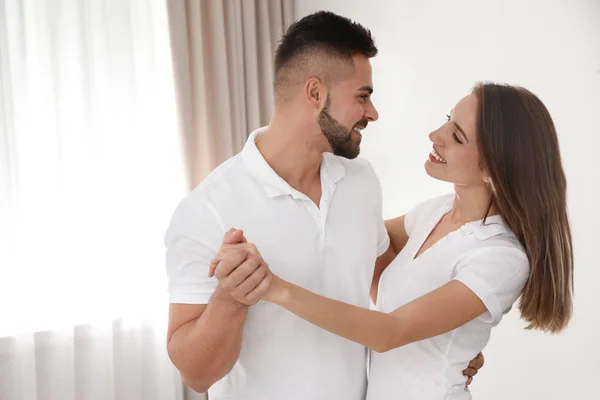 Adorável jovem casal dançando juntos em casa — Fotografia de Stock