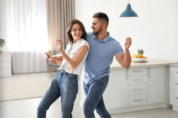 Adorável jovem casal dançando na cozinha em casa — Fotografia de Stock