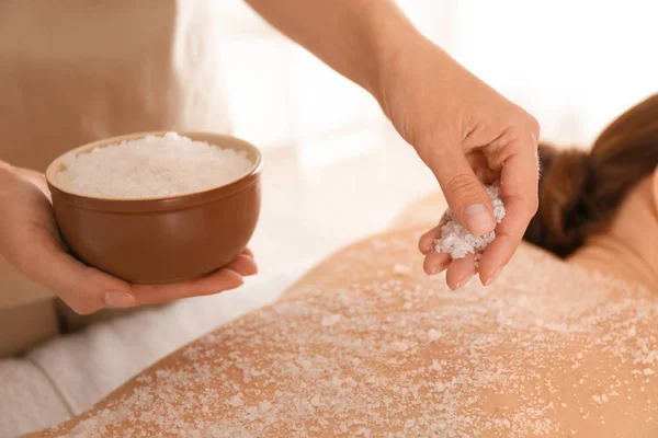 Jovem mulher tendo procedimento de limpeza corporal com sal marinho no spa — Fotografia de Stock