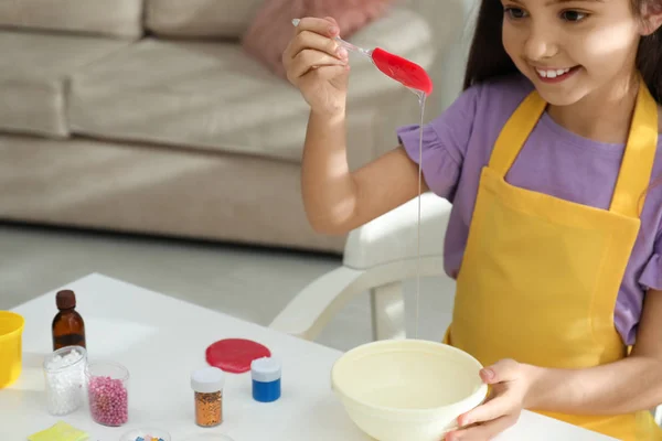 Menina bonito misturando ingredientes com espátula de silicone na guia — Fotografia de Stock