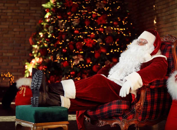 Άγιος Βασίλης Αναπαύεται Στην Πολυθρόνα Κοντά Διακοσμημένο Χριστουγεννιάτικο Δέντρο Εσωτερικούς — Φωτογραφία Αρχείου