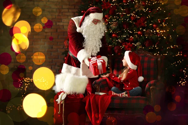 Santa Claus dando regalo a niña cerca del árbol de Navidad en — Foto de Stock