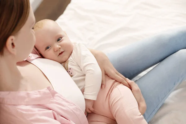 Junge Frau mit ihrem kleinen Baby, das sich nach dem Stillen ausruht — Stockfoto