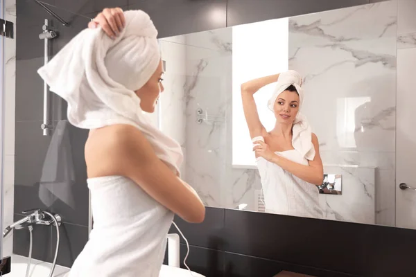 Mujer joven depilando su axila en el baño —  Fotos de Stock