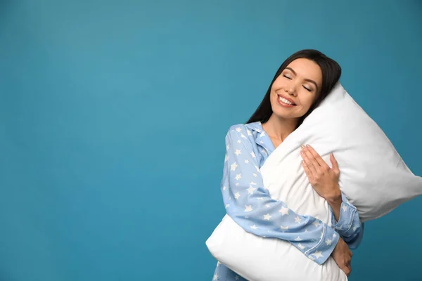 Beautiful Asian woman with pillow on blue background, space for — ストック写真