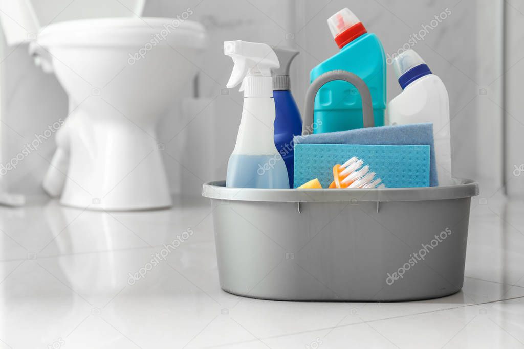 Cleaning supplies and toilet bowl in bathroom