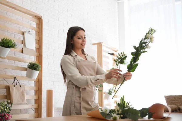 Floristería haciendo hermoso ramo en la mesa en el taller — Foto de Stock