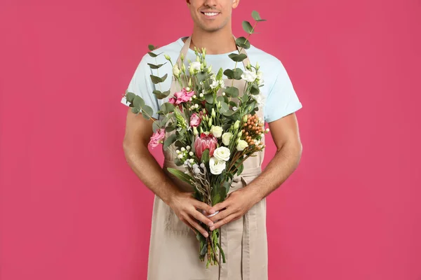 Bloemist met mooi boeket op roze achtergrond, close-up — Stockfoto