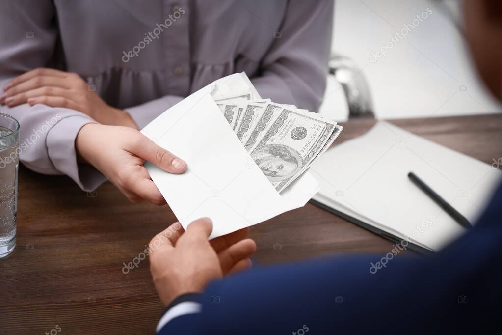 Man giving bribe money to woman at table, closeup