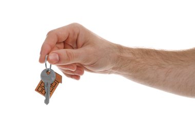 Emlakçının elinde beyaz arka planda ıvır zıvırlı ev anahtarı var.