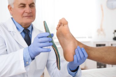 Klinikte erkek ortopedist ayağına taban takıyor.