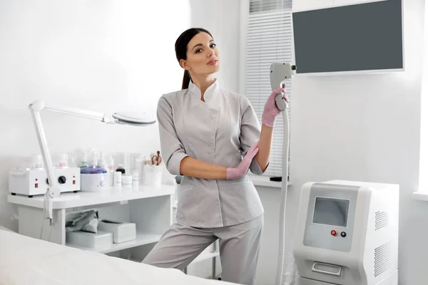 Jovem mulher segurando epilator laser profissional no salão de beleza — Fotografia de Stock