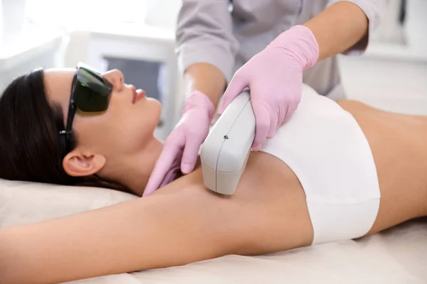 Mulher jovem submetida a procedimento de depilação a laser no salão de beleza — Fotografia de Stock