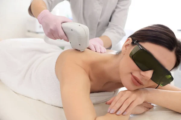 Mulher jovem submetida a procedimento de depilação a laser no salão de beleza — Fotografia de Stock