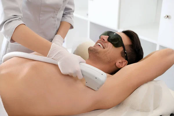 Młody mężczyzna przechodzących procedury depilacji laserowej w salonie piękności — Zdjęcie stockowe