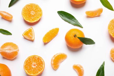 Taze mandalinalı kompozisyon ve beyaz arka planda yapraklar, düz. Citrus meyvesi.