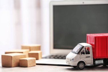 Bilgisayarın yanındaki oyuncak kamyon masada. Lojistik ve toptan satış kavramı