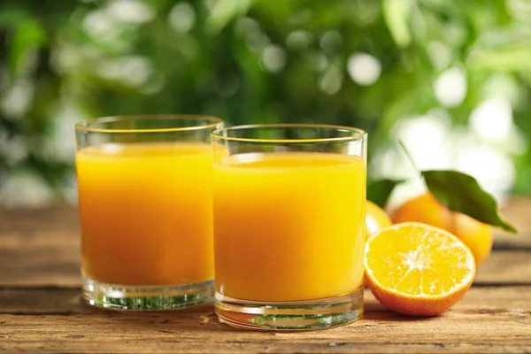 Sklenice čerstvé mandarinky a ovoce na dřevěném stole — Stock fotografie