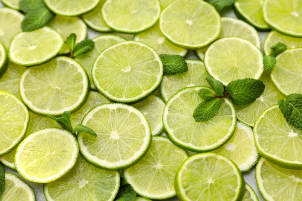 Slices of fresh juicy limes as background, closeup